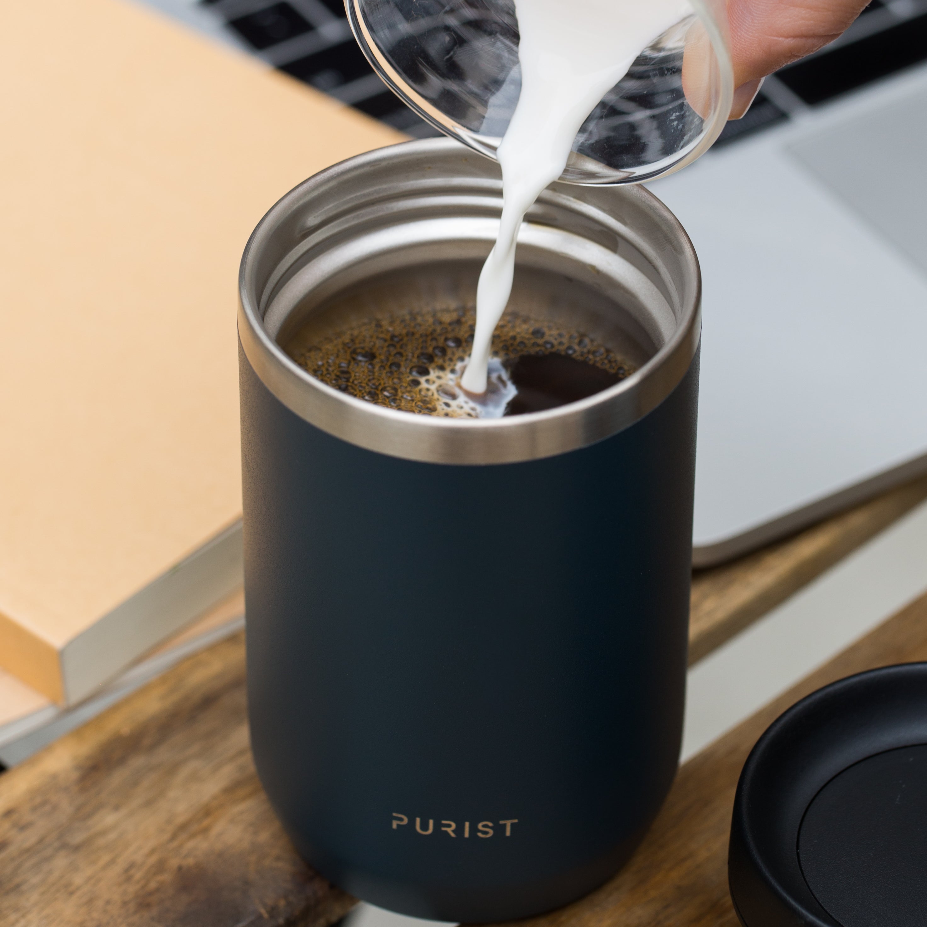 Person pouring milk into coffee in Purists' 10oz Maker in Drift.