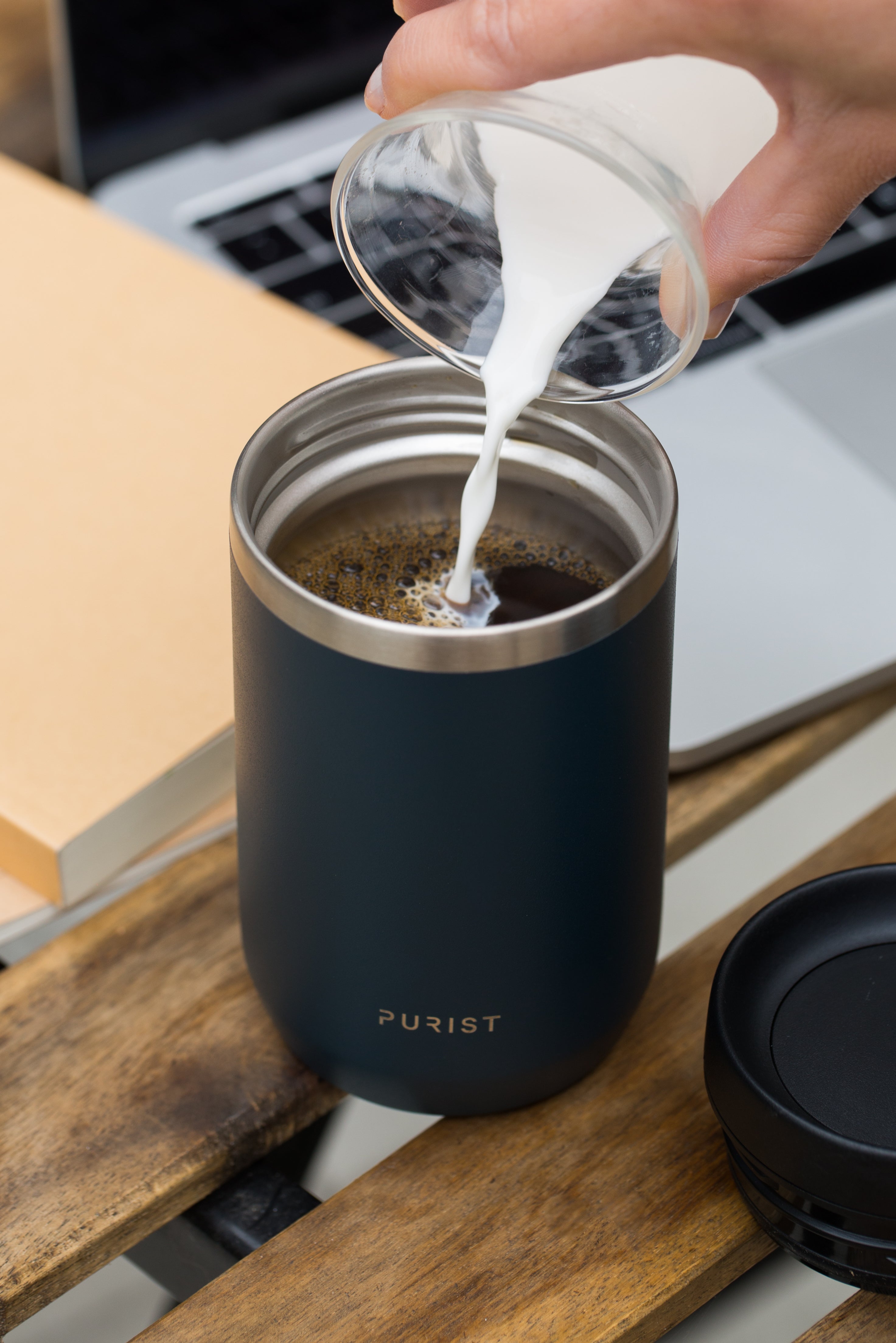Person pouring milk into coffee in Purists' 10oz Maker in Drift.