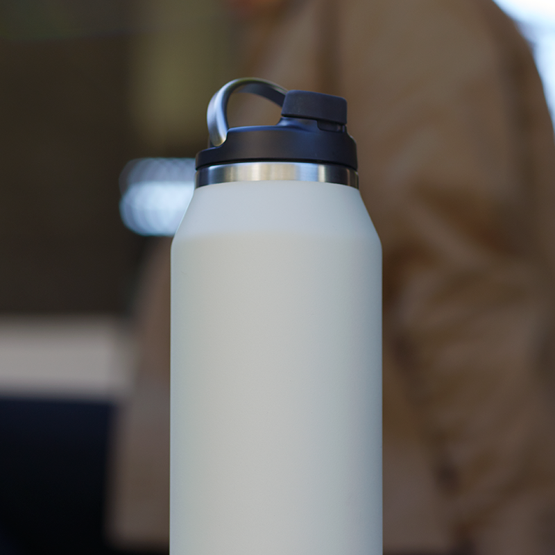Lifestyle shot of Purist 32 oz glass lined bottle in Bone.