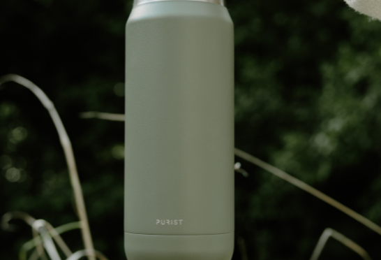 Person holding a Purist green insulated bottle 