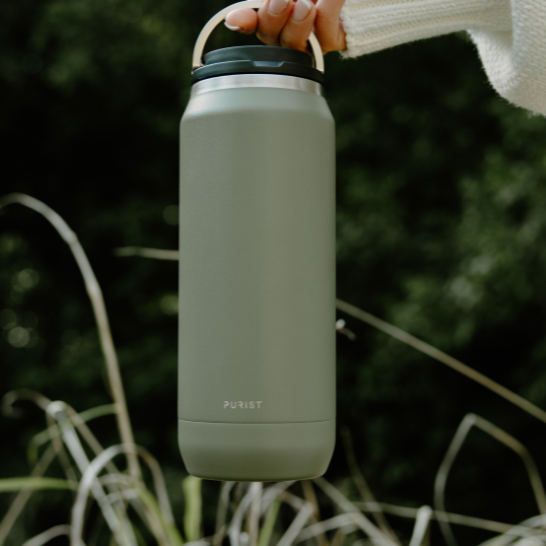 Person holding a Purist green insulated bottle 