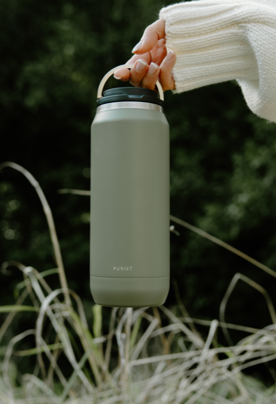 Person holding a Purist green insulated bottle 