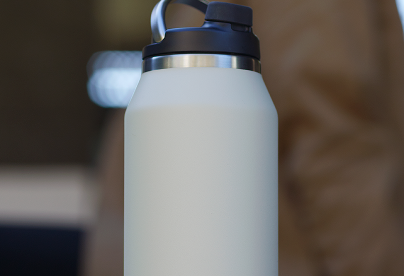 Lifestyle shot of Purist 32 oz glass lined bottle in Bone.